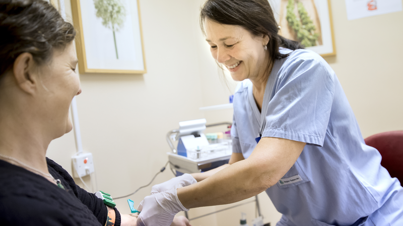 Sjuksköterska tar ett blodprov på en kvinna. Kopparbergs vårdcentral, Region Örebro län